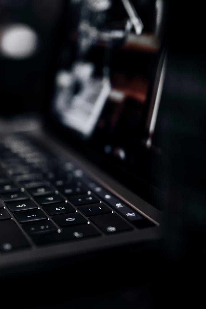 our-story A detailed close-up of a laptop keyboard in a dark setting, showcasing technology.
